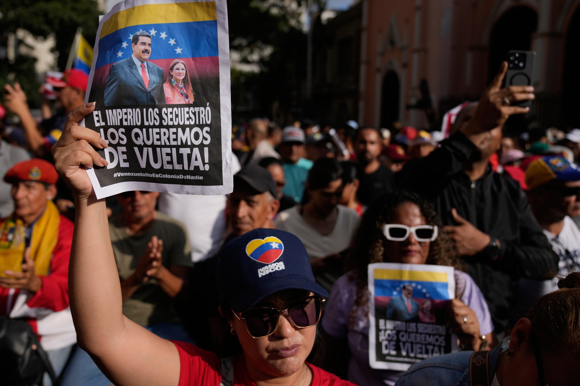 Government supporters hold posters that read in Spanish, “The empire kidnapped them; we want them back,” during a protest demanding President Nicolas Maduro and first lady Cilia Flores release from U.S. custody in Caracas, Venezuela, Sunday, Jan. 4, 2026. (AP Photo/Ariana Cubillos)

