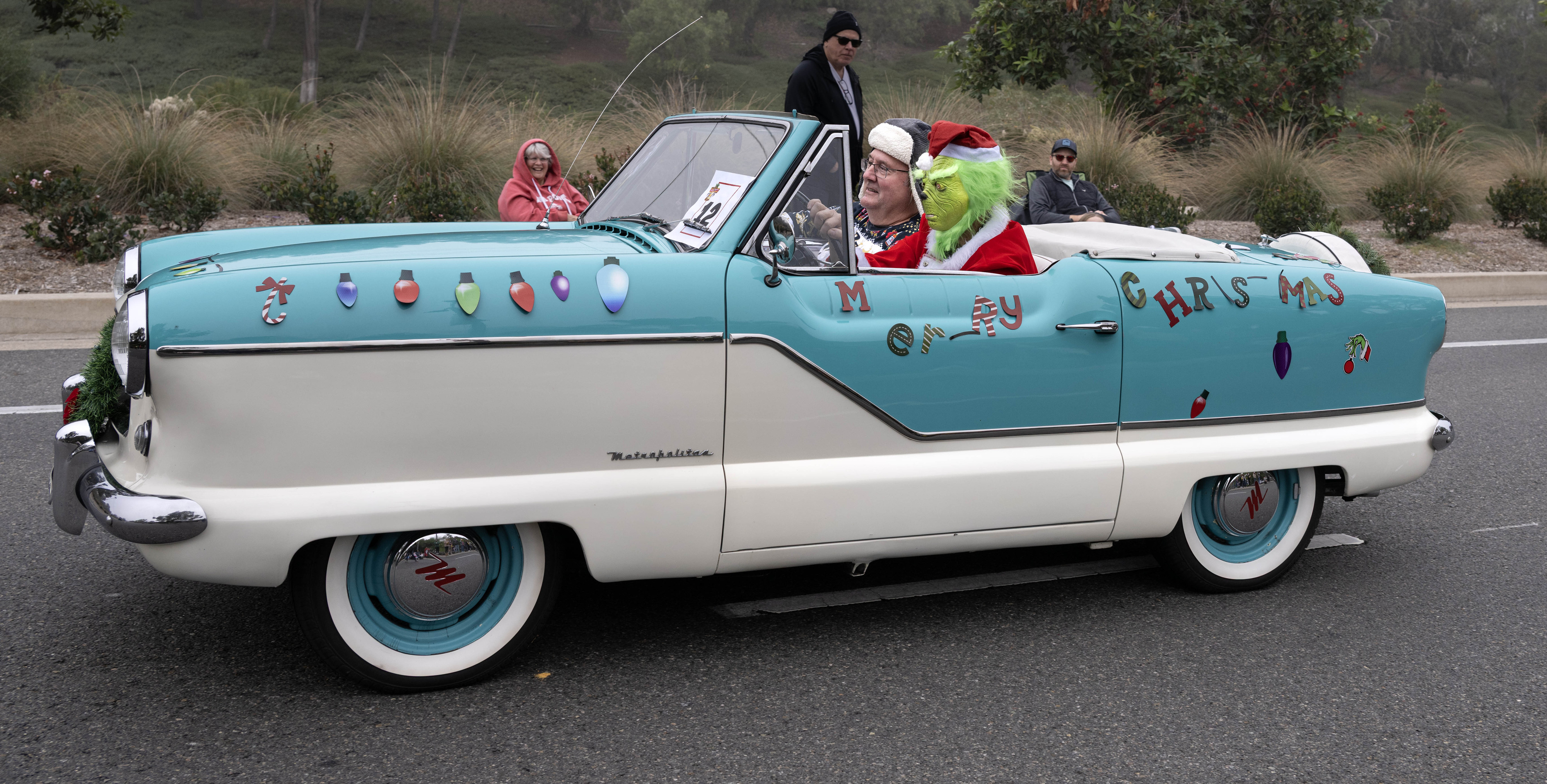 A grumpy driver leads the way as So Cal Mets, a group of Nash Metropolitan car owners dedicated to showing off the charm, history and uniqueness of the 1950s-1060s era compact car, take part in the Laguna Niguel Holiday Parade on Saturday, December 13, 2025.(Photo by Mindy Schauer, Orange County Register/SCNG)
